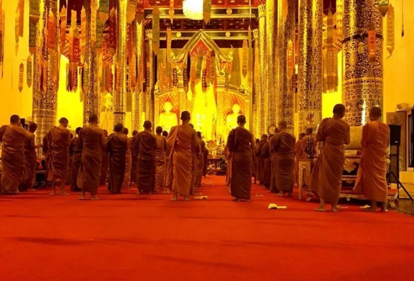 CMLocals Chiang Mai Locals Thai Customs monk in orange robes lighting candles at temple